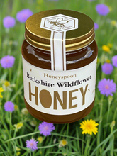 Jar of Berkshire wildflower honey with background of spring flowers