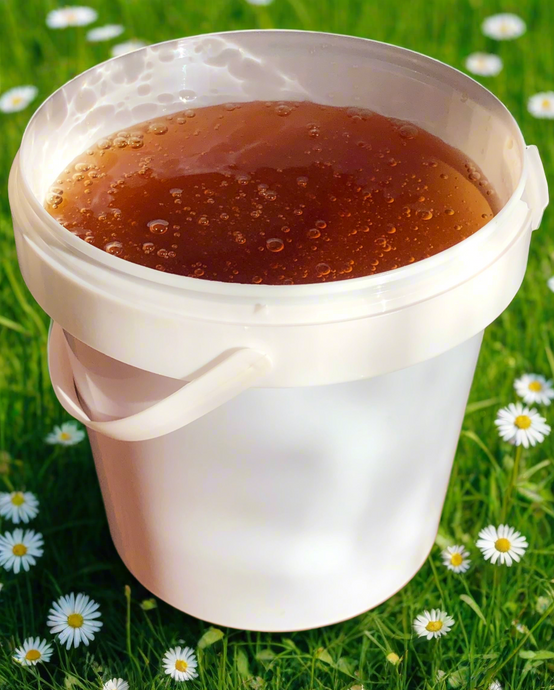 Wildflower Honey Tub (1.5Kg) with background of wildflowers