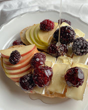 Plate of cheese and fruit drizzled with honey